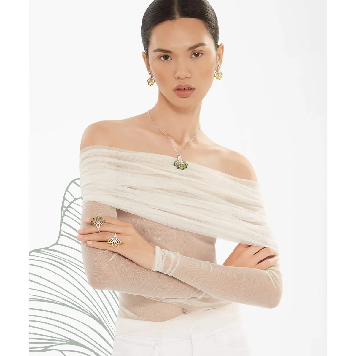 A model wearing a green Garrard Lotus pendant with matching earrings and rings