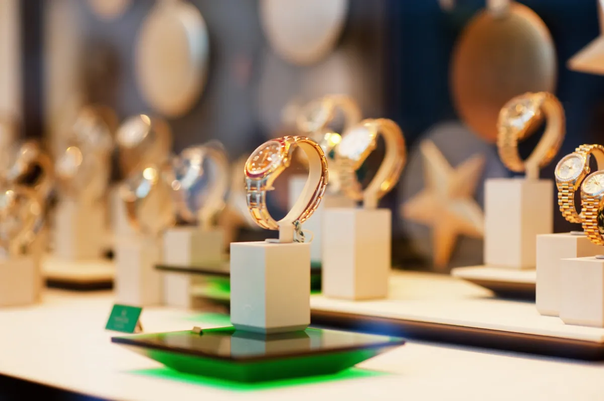 Gold wristwatches displayed on white stands in a jeweller’s window